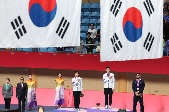 오상욱과 구본길이 25일 오후 중국 항저우 디안즈대학 체육관에서 열린 2022 항저우 아시안게임 펜싱 남자 사브르 개인전 메달 수여식에서 국기에 대한 경례를 하고 있다. 이번 대회에서 오상욱과 구본길은 각각 금메달과 은메달을 차지했다. 2023.9.25 뉴스1