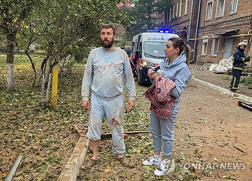 6일(현지시간) 새벽 우크라이나 북동부 하르키우시에 떨어진 러시아군 미사일에 10살 아들을 잃은 주민 올레흐 비츠코가 망연자실한 표정으로 서 있다.   [하르키우 로이터=연합뉴스]