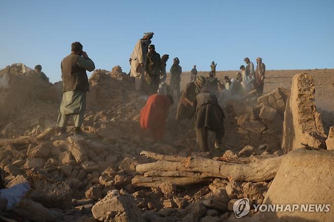 무너진 건물 잔해 수색하는 아프간 주민들 [AFP=연합뉴스. 재판매 및 DB 금지]