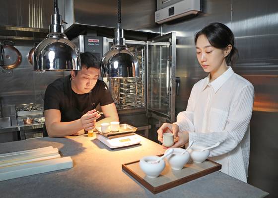 Level: 0's executive chef Denny Han, left, and design studio Stimuli's creative director Jeon Jin-hyun serve dishes under their special collaboration menu dubbed "Sensory Manipulation," on Sept. 22. [PARK SANG-MOON]