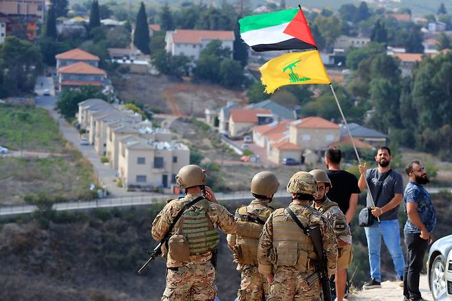 9일(현지 시각) 레바논과 이스라엘 국경 마을 카프르 킬라에서 한 남성이 팔레스타인과 헤즈볼라 깃발을 흔들고 있다. /연합뉴스