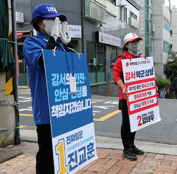 지난 8일 서울 강서구의 한 교회 앞에서 진교훈 더불어민주당 강서구청장 후보 선거운동원(왼쪽 앞)과 김태우 국민의힘 강서구청장 후보 선거운동원이 나란히 서서 지지를 호소하고 있다. [사진=뉴시스]