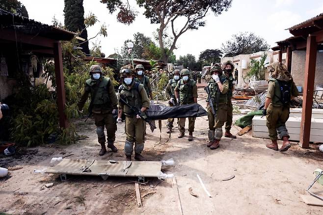 10일(현지시간) 이스라엘 크파르 아자 키부츠에서 군인들이 하마스에게 살해당한 주민들의 시신을 옮기고 있다. /사진=AFP
