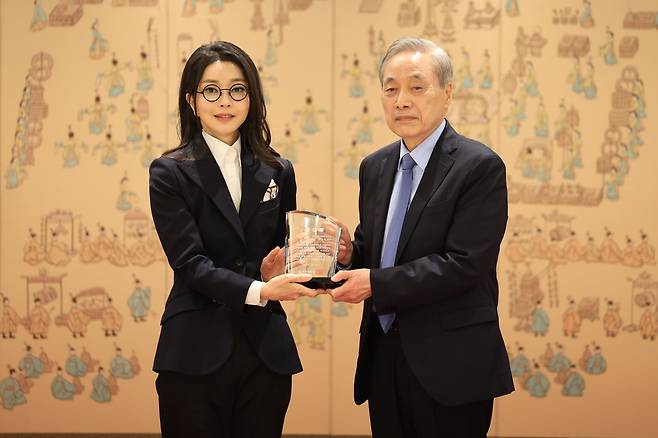 윤석열 대통령 부인 김건희 여사가 12일 서울 용산 대통령실 청사에서 열린 대한암협회 명예회장 추대행사에서 이민혁 대한암협회 회장으로부터 추대패를 받은 뒤 기념촬영을 하고 있다./대통령실 제공