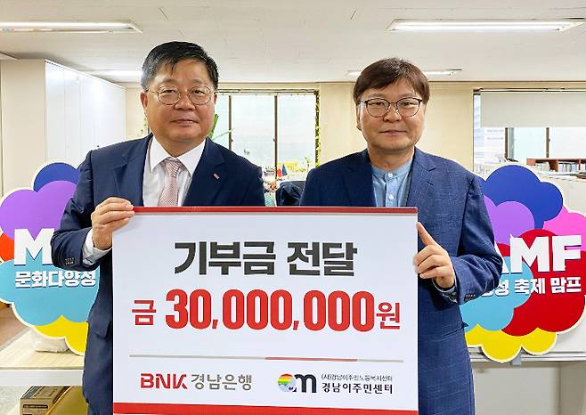 BNK경남은행 박상호 상무(사진 왼쪽)가 (사)경남이주민노동복지센터 이철승 대표에게 '기부금 3000만원 기탁 증서'를 전달하고 있다. 경남은행 제공