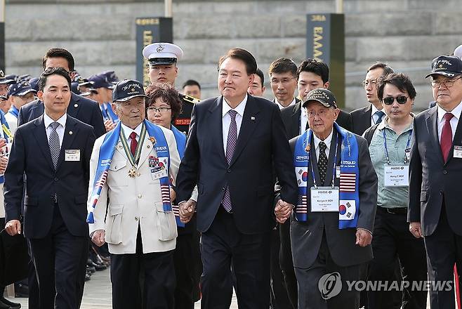 6·25 참전용사와 함께 손잡고 입장하는 윤석열 대통령 (서울=연합뉴스) 임헌정 기자 = 윤석열 대통령이 12일 오후 서울 용산 전쟁기념관 평화의광장에서 열린 제73주년 장진호 전투 기념행사에 6·25 참전용사와 함께 입장하고 있다. 2023.10.12 kane@yna.co.kr