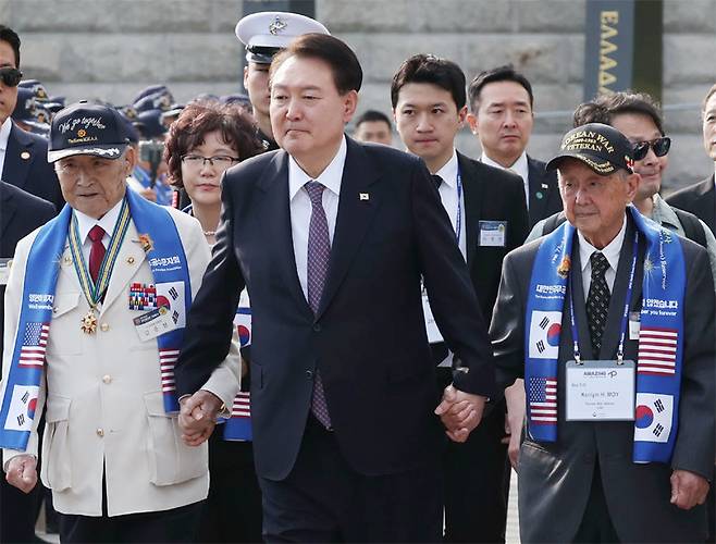 윤석열 대통령이 12일 서울 용산 전쟁기념관 평화의 광장에서 열린 제73주년 장진호 전투 기념행사에서 김응선 옹(왼쪽)과 켄림 힌쇼 모이 옹(오른쪽) 등 한미 6·25 참전용사들 손을 잡고 입장하고 있다. 대통령실사진기자단