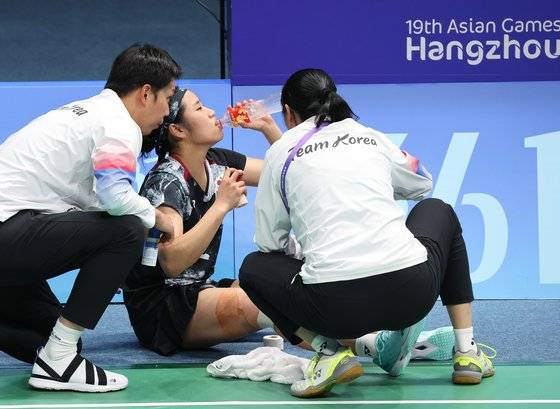 항저우 아시안게임 여자 단식 경기 도중 무릎 통증으로 인해 응급 치료를 받는 안세영(가운데). 연합뉴스