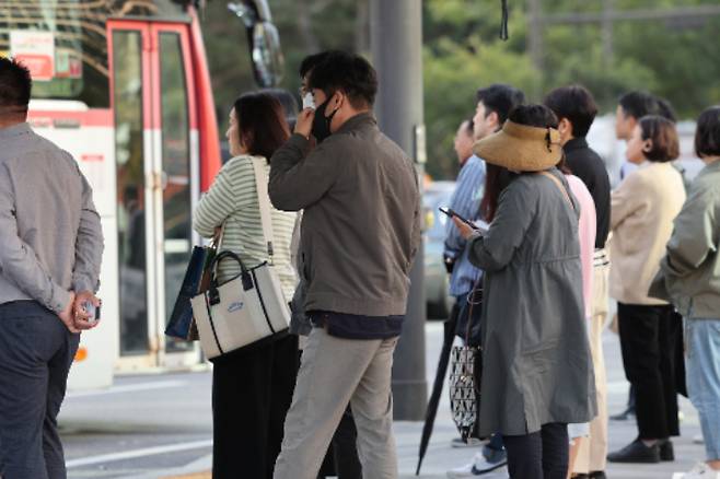 쌀쌀한 가을 날씨를 보인 5일 오전 서울 종로구 광화문네거리에서 외투와 긴팔 옷을 입은 시민들이 횡단보도 신호를 기다리고 있다. 연합뉴스