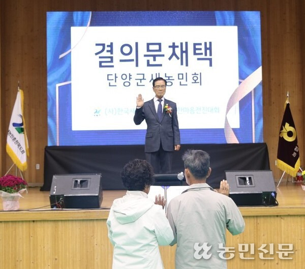 곽찬주 한국새농민회 충북도회장(무대 위)이 지역사회 발전과 희망찬 농촌건설을 다짐하는 결의문을 채택하고 있다.