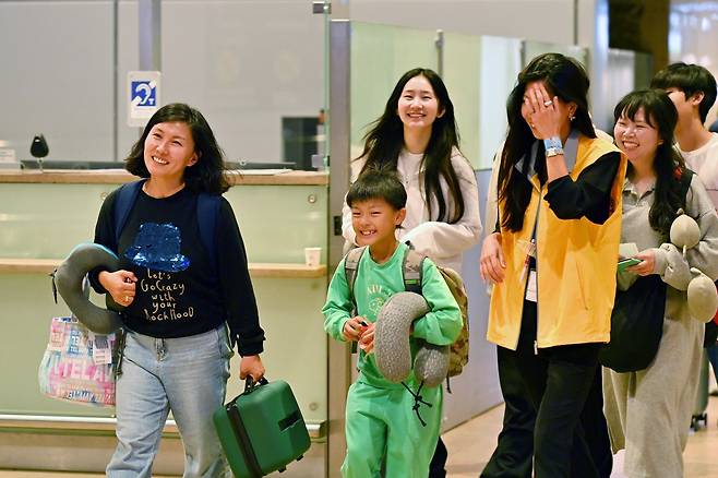 13일(현지시각) 저녁 이스라엘 텔아비브 공항에서 외교부 신속대응팀 인원(노란 조끼)을 만난 우리 교민들이 환하게 웃고 있다.2023.10.14/국방부