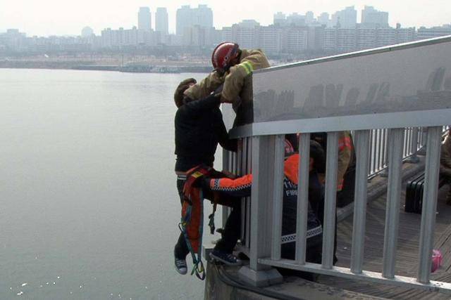 지난 2014년 서울 마포대교 전망대에서 자살시도자가 발생해 구조대원들이 투신자를 구조하고 있다. 한국일보 자료사진