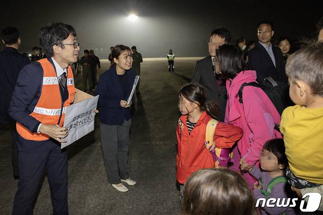 14일 밤 이스라엘에서 출발해 경기 성남 서울공항에 도착한 일본인에게 주한일본대사관 직원이 수속 안내를 하고 있다. 구조 인원은 우리 국민 163명과 일본인 51명, 싱가포르인 6명 등 총220이다. 2023.10.15/뉴스1 ⓒ News1 사진공동취재단