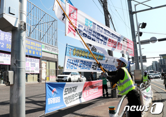 울산시 도시미관 작업 관계자들이 16일 울주군 장검교차로에서 정당현수막을 포함한 거리에 게시된 불법현수막에 대해 일제 정비를 실시하고 있다. (울산광역시제공)2023.10.16/뉴스1 ⓒ News1 김지혜 기자