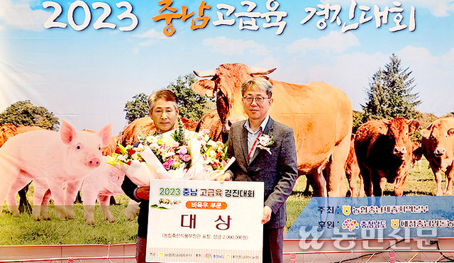 10일 열린 ‘2023 충남 고급육 경진대회’에서 편용범씨(왼쪽)가 오진기 충남도 농림축산국장으로부터 대상을 받고 있다.