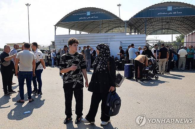 "가자지구 남쪽 이집트 통행 재개 위해 일시 휴전 합의" [AFP=연합뉴스] 지난 14일(현지시간) 이스라엘의 공격이 계속 되자 외국 여권을 소지한 사람들이 이집트로 건너가기 위해 라파 통로에서 대기하는 모습.