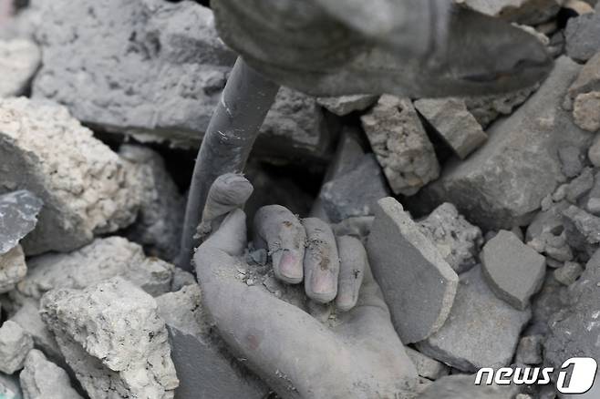 16일 (현지시간) 팔레스타인 무장 정파 하마스의 공격에 대응한 이스라엘 군의 포격을 받은 가자 지구 칸 유니스의 주택 잔해 속에 숨진 팔레스타인 주민의 손이 보인다. 2023. 10.17 ⓒ 로이터=뉴스1 ⓒ News1 우동명 기자