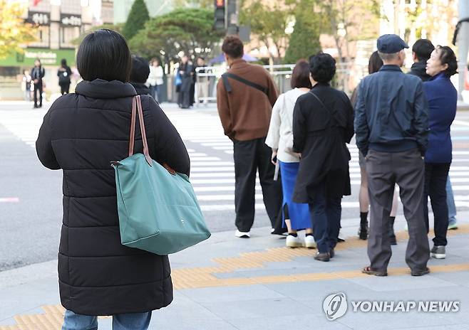 등장한 두꺼운 패딩 (서울=연합뉴스) 김성민 기자 = 낮과 밤의 기온 차가 10~15도로 예상돼 쌀쌀한 가을 날씨를 보인 16일 오전 서울 종로구 세종대로 사거리에서 시민들이 횡단보도를 건너기 위해 기다리고 있다. 2023.10.16 ksm7976@yna.co.kr