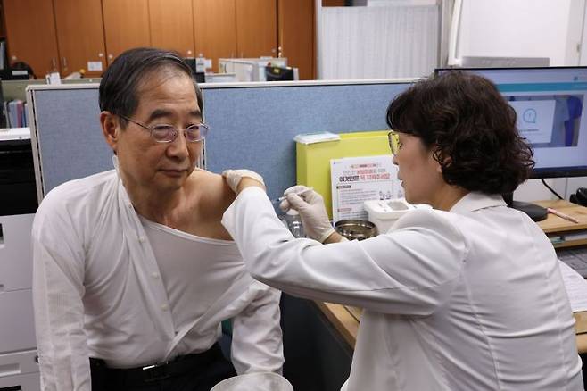 한덕수 국무총리가 최근 유행 변이에 대응해 개발된 코로나19 신규 백신의 겨울철 접종이 시작된 19일 서울 종로구 보건소에서 신규 개발된 XBB.1.5 단가 백신을 접종받고 있다. [이미지출처=연합뉴스]