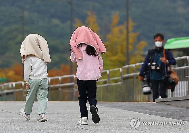 갑작스러운 비, 우산이 되어준 겉옷 (서울=연합뉴스) 김도훈 기자 = 8일 오후 서울 광화문광장을 찾은 어린이들이 비가 내리자 겉옷을 머리에 쓴 채 길을 지나고 있다. 2023.10.8 superdoo82@yna.co.kr