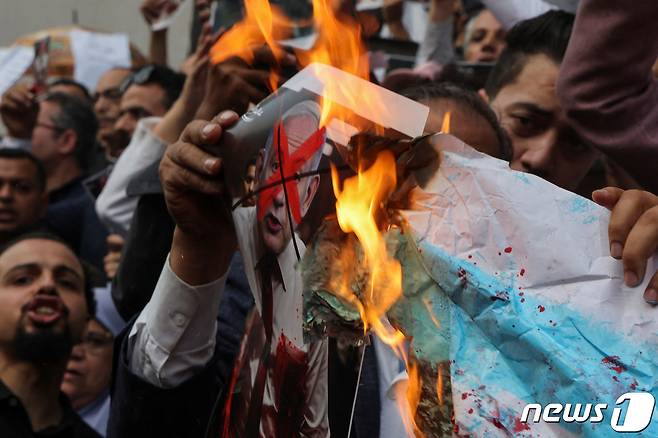 18일(현지시간) 이집트인들이 카이로에서 열린 반이스라엘 집회에서 네타냐후 이스라엘 총리와 이슬라엘 국기를 불태우고 있다. ⓒ 로이터=뉴스1 ⓒ News1 박형기 기자