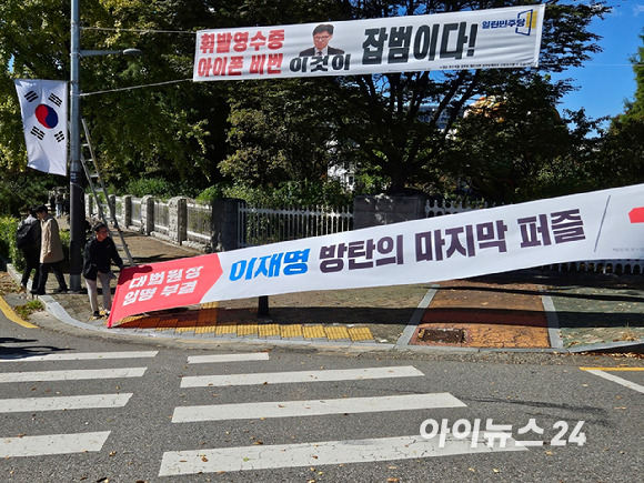 국민의힘 관계자가 20일 서울 여의도 국회 근처 서강대교 남단 사거리에 게시됐던 '대법원장 임명 부결·이재명 방탄의 마지막 퍼즐' 현수막을 철거한 후 '국민의 뜻대로 민생 속으로'라는 문구가 적힌 현수막을 달고 있다. [사진=김주훈 기자]