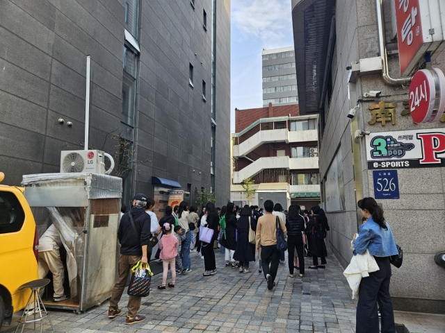 지난 21일 ‘예비 초1’ 자녀를 둔 학부모들이 영어학원 앞에서 자녀를 기다리고 있다. 정유민 기자