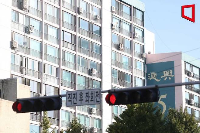 한국은행이 기준금리를 0.5% 포인트 올리면서 부동산 거래시장의 빙하기가 장기화될 것으로 보인다. 13일 서울 시내 한 아파트 인근 신호등에 빨간불이 켜져 있다.