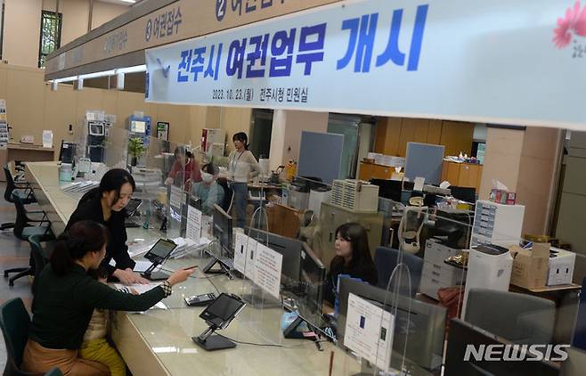 [전주=뉴시스] 김얼 기자 = 전주시가 여권 발행 업무를 시작한 23일 전북 전주시 전주시청 민원실에서 1호 여권 발급자가 여권을 발급받기 위해 절차를 밟고 있다. 2023.10.23. pmkeul@newsis.com