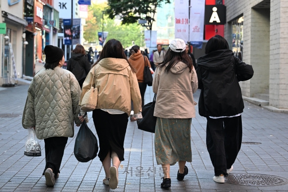 외투 껴입은 관광객들 - 일부 산간 지역의 아침 최저기온이 영하로 떨어진 22일 오전 서울 명동을 찾은 관광객들이 두꺼운 옷을 입은 채 걷고 있다. 23일 아침 최저기온은 5∼14도, 낮 최고기온은 19∼22도로 평년과 비슷하겠지만 낮과 밤 온도 차가 커 건강관리에 유의해야 한다. 도준석 기자