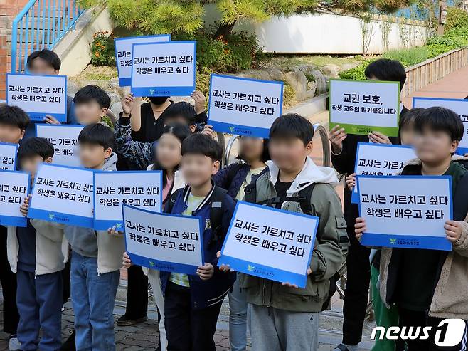 24일 광주 북구 양지초 앞에서 열린 윤수연 교사 교권회복 촉구 집회에서 하교하던 초등학생들이 피켓을 들고 동참했다.2023.10.24./뉴스1 ⓒ News1 서충섭 기자