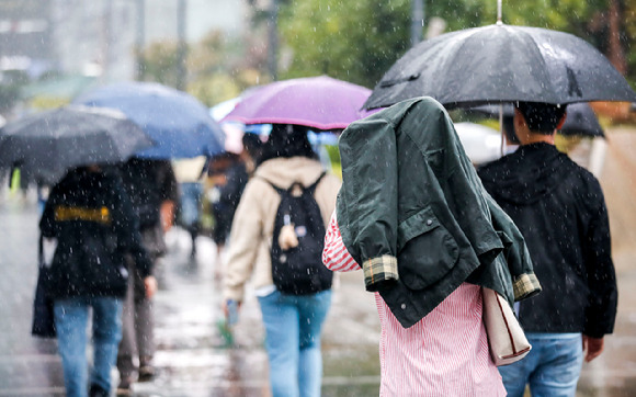 비가 내린 19일 서울 강남구 코엑스 인근에서 옷을 뒤집어 쓴 한 시민이 이동하고 있다. [사진=뉴시스]