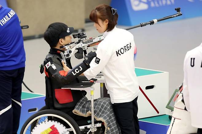 이철재와 '로더' 강혜영 (서울=연합뉴스) 이철재가 24일 중국 항저우 푸양 인후 스포츠센터에서 열린 2022 항저우 장애인아시아경기대회 혼성 SH2 R9 50ｍ 공기소총복사 결승전에서 아내이자 '로더'인 강혜영 씨의 도움을 받아 표적을 조준하고 있다. [대한장애인체육회 제공. 재판매 및 DB 금지]