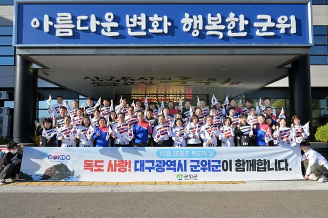 대구 군위군 직원들이 25일 독도의 날을 맞아 독도티셔츠를 입고 출근해 퍼포먼스를 펼치고 파이팅을 외치고 있다. 군위군 제공