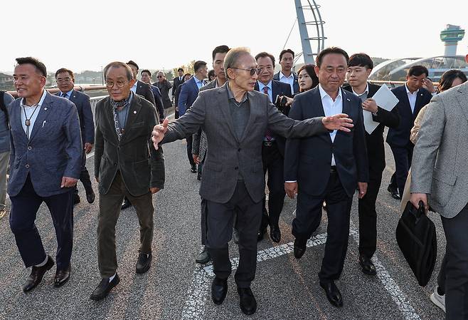 이명박 전 대통령(가운데)이 25일 오후 경기도 여주시 한강문화관 인근에서 열린 4대강 강천보 걷기 행사에 참석해 관계자들과 걷고 있다. 연합뉴스