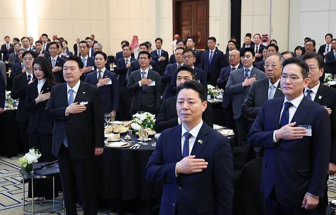 사우디아라비아를 국빈 방문 중인 윤석열 대통령과 김건희 여사가 23일(현지시간) 리야드의 메리어트 호텔에서 열린 동행 경제인 만찬에서 국기에 경례하고 있다. ㅔ연합]