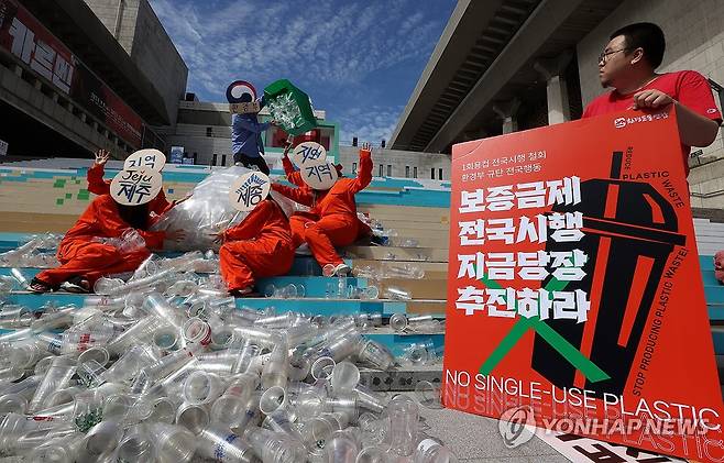 환경운동연합 등 환경단체 회원들이 지난달 21일 오전 서울 종로구 세종문화회관 앞에서 1회용컵 보증금제 전국 시행 철회를 규탄하는 퍼포먼스를 하고 있다. [연합뉴스 자료사진]