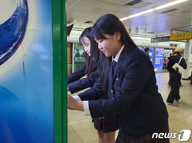 25일 부산 덕문중 학생들이 부산 도시철도 2호선 서면역 자판기에 점자를 붙이고 있다. 2023.10.25. ⓒ News1 DB 노경민 기자