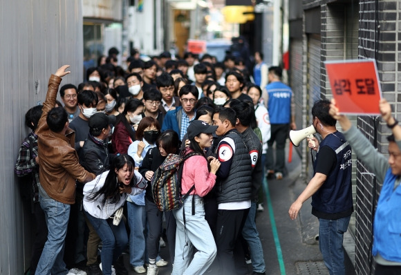 서울시와 광진구, 광진경찰서, 광진소방서 관계자 등이 핼러윈을 일주일여 앞둔 25일 건대입구 ‘맛의 거리’에서 인파감지 시스템을 점검하고 밀집 위험 ‘심각’ 단계를 가정해 훈련하고 있다. 연합뉴스