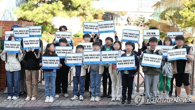 "교권 보호" 동참한 학생들 (광주=연합뉴스) 천정인 기자 = 24일 오후 광주 북구 한 초등학교 앞에서 학생들이 이 학교 A 교사에 대한 교권 회복 촉구 집회에 참여하고 있다. A 교사는 학생 간 싸움을 말리는 과정에서 책상을 밀쳤다가 아동학대 혐의로 학부모에게 고소당해 검찰에서 무혐의 처분을 받았다. 학교 측은 이날 A 교사에 대한 교권보호위원회를 열었다. 2023.10.24 iny@yna.co.kr