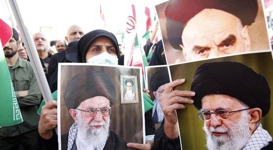이란은 이슬람 근본주의 시아파 종교지도자가 다스리는 신정국가다. 지난해 9월 이란 수도 테헤란에서 친정부 성향의 시위대가 이란의 초대 최고지도자 아야톨라 호메이니(오른쪽 위)와 현 최고지도자 아야톨라 알리 하메네이(아래쪽 좌우)의 사진을 들고 행진하고 있다. EPA=연합뉴스