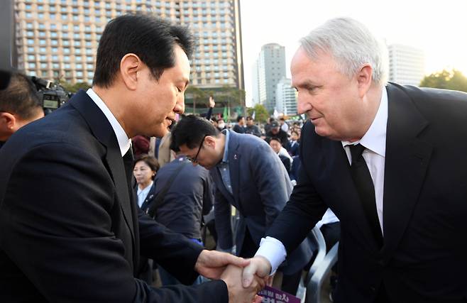 오세훈 서울시장과 국민의힘 인요한 혁신위워장이 29일 오후 서울 중구 서울광장에서 열린 이태원 참사 1주기 시민추모대회에서 악수하고 있다. [연합]