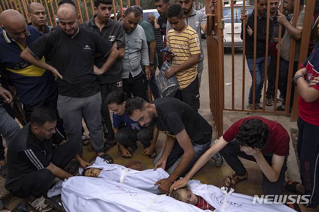 [AP/뉴시스] 29일 가자 팔레스타인 주민들이 남부 난민촌 칸 유니스 내 시체안치소에서 이스라에 공습에 사망한 가족들 시신을 어루만지고 있다