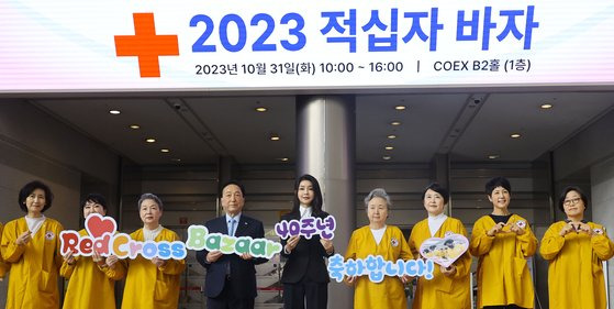 김건희 여사가 31일 오전 서울 강남구 삼성동 코엑스에서 열린 `2023 대한적십자 바자' 행사에 참여해 테이프 커팅을 한 뒤 적십자 바자 40회를 기념하는 손팻말을 들고 기념촬영을 하고 있다. 김현동 기자