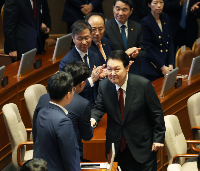 윤석열 대통령이 31일 국회 본회의장에서 시정연설을 마치고 퇴장하며 의원들과 악수하고 있다.연합뉴스