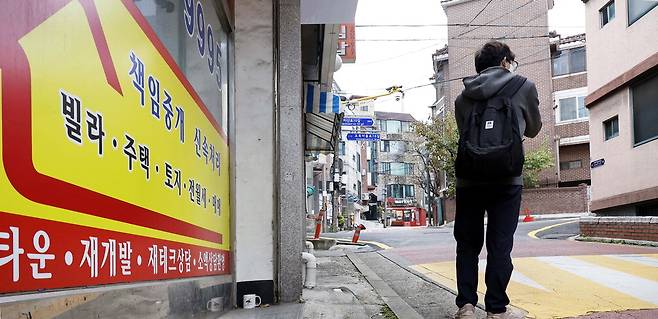 1일 서울 강서구 화곡동 빌라 밀집 지역 일대에 위치한 공인중개사무소 앞에 한 행인이 서 있다. 약 1년 전 불법 중개업자들이 벌인 전세사기 사건이 발생한 이후 이 지역의 전월세 문의가 급감했다.  김호영 기자