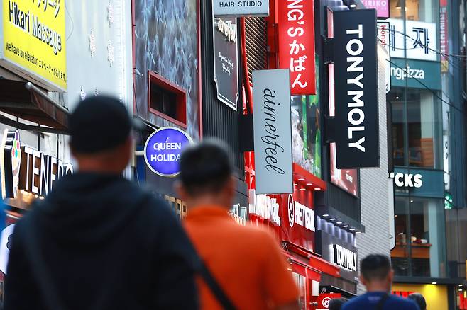 Pedestrians walk along an alleyway in Myeong-dong shopping district in central Seoul on Oct. 9. (Yonhap)