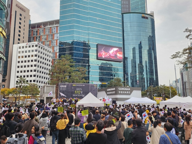 ‘2023 리바이벌 코리아’ 참가자들이 5일 서울 강남구 강남역 11번 출구 인근에서 열린 집회장에서 태극기를 흔들며 애국가를 부르고 있다.