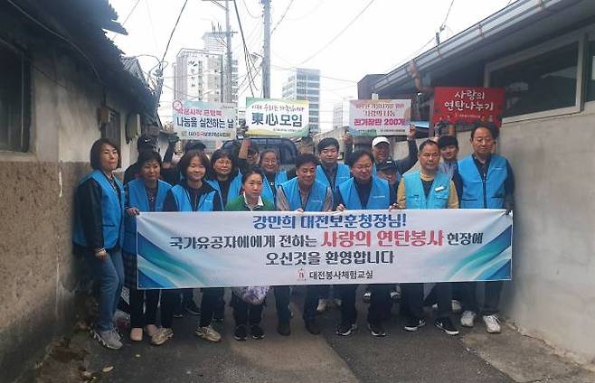 4일 오전 강만희 대전보훈청장과 권흥주 대전봉사체험교실 회장 등 봉사자들이 참전용사 가정 연탄 봉사 후 기념 촬영을 하고 있다.대전보훈청 