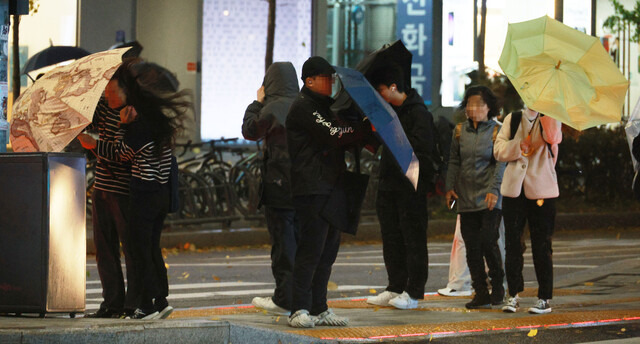 지난 6일 저녁 거센 비바람이 부는 서울 홍대입구역 인근에서 시민들이 강풍을 맞으며 걸어가고 있다. 연합뉴스